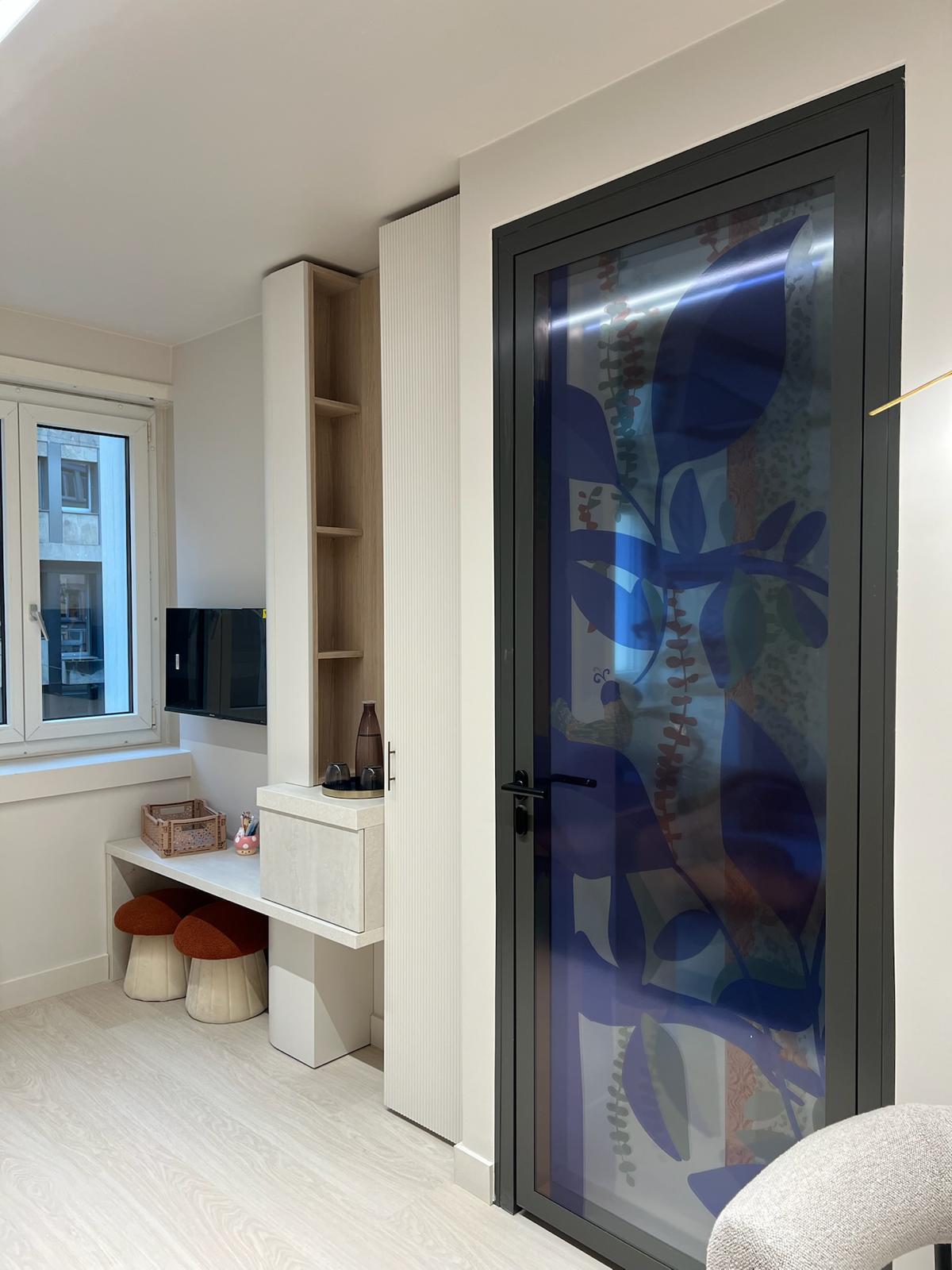 Espace enfants — bureau, tabourets champignons et porte vitrée à motif feuillage bleu