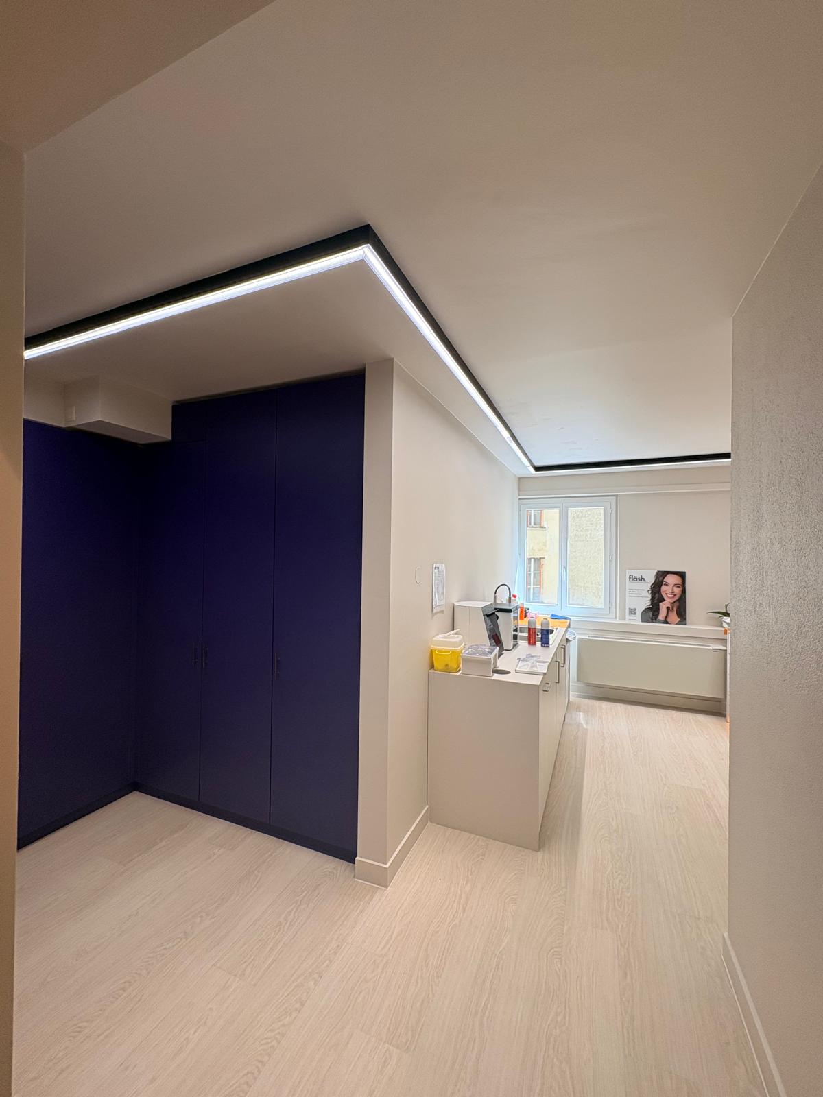 Salle de soin — façade meuble bleu nuit, plafonnier LED encadré et plan de travail clair