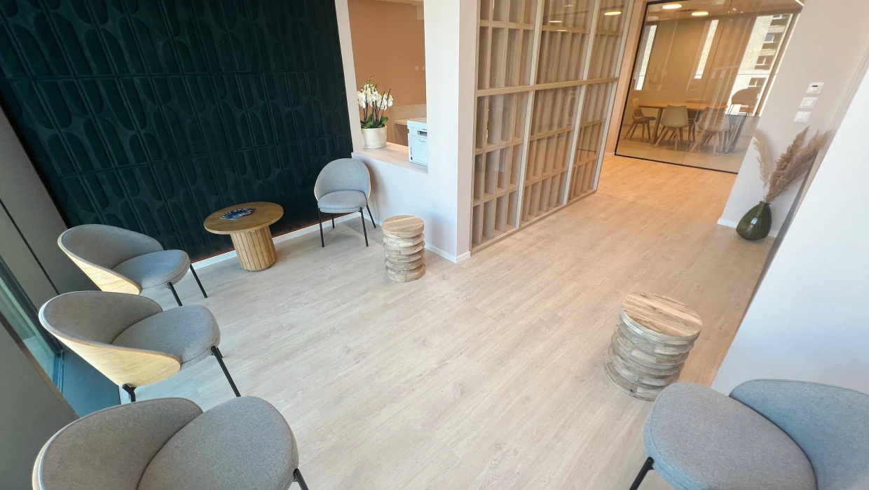 Salle d'attente — assises bouclées, mur graphique vert sapin et claustra bois