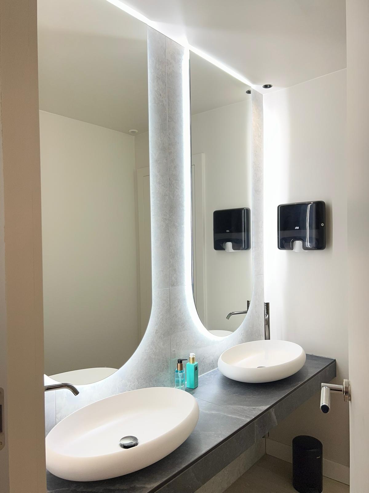 Sanitaires — double vasque, plan céramique gris et grand miroir rétroéclairé