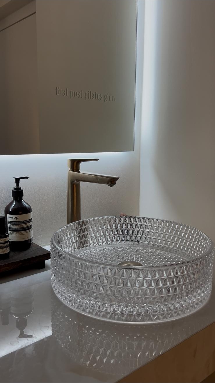Sanitaires — vasque cristal facetté, robinetterie laiton et miroir gravé « that post pilates glow »