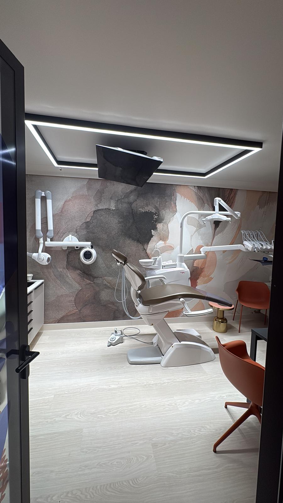 Salle de soin — fauteuil champagne, fresque murale aquarelle terracotta et plafond LED encadré